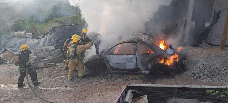 Bomberos sofocando carro quemandose