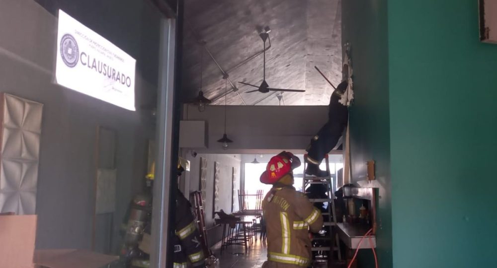 Bomberos sofocando incendio en restaurante