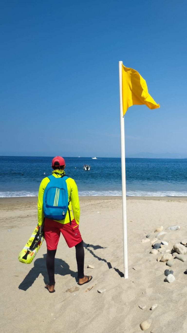 Guardavida junto a bandera amarilla