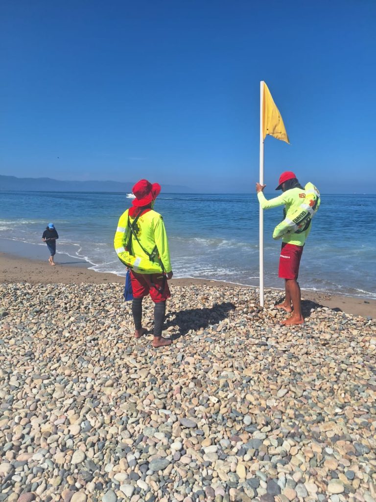 Guardavidas intalando bandera amarilla en playa