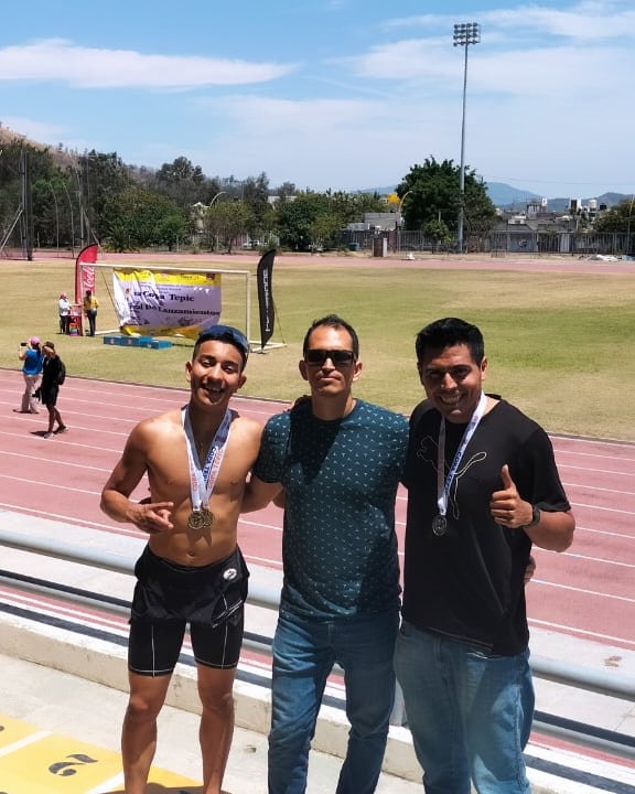 Pablo Delgadillo Cortés con deportistas en pista