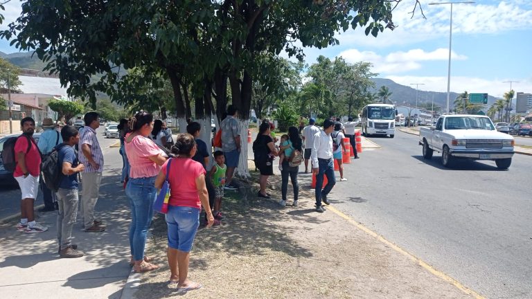 Población esperando camión en parada provicional