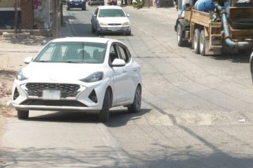 Automóvil esquivando bache por la banqueta