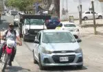 Autos transitando en calle con baches
