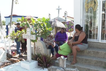 Familia visitando panteón por el Día de las Madres