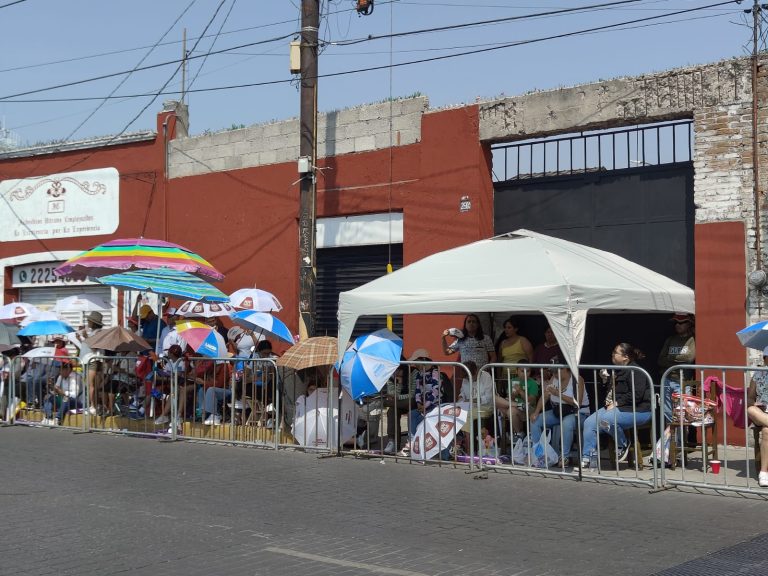 Gente en las calles esperando por el desfile por la Batalla de Puebla