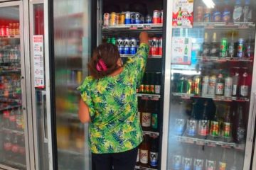 Mujer sacando cervezas de refrigerador