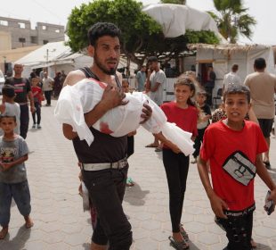 Palestino cargando a infante muerto tras ataque de Israel a Rafh