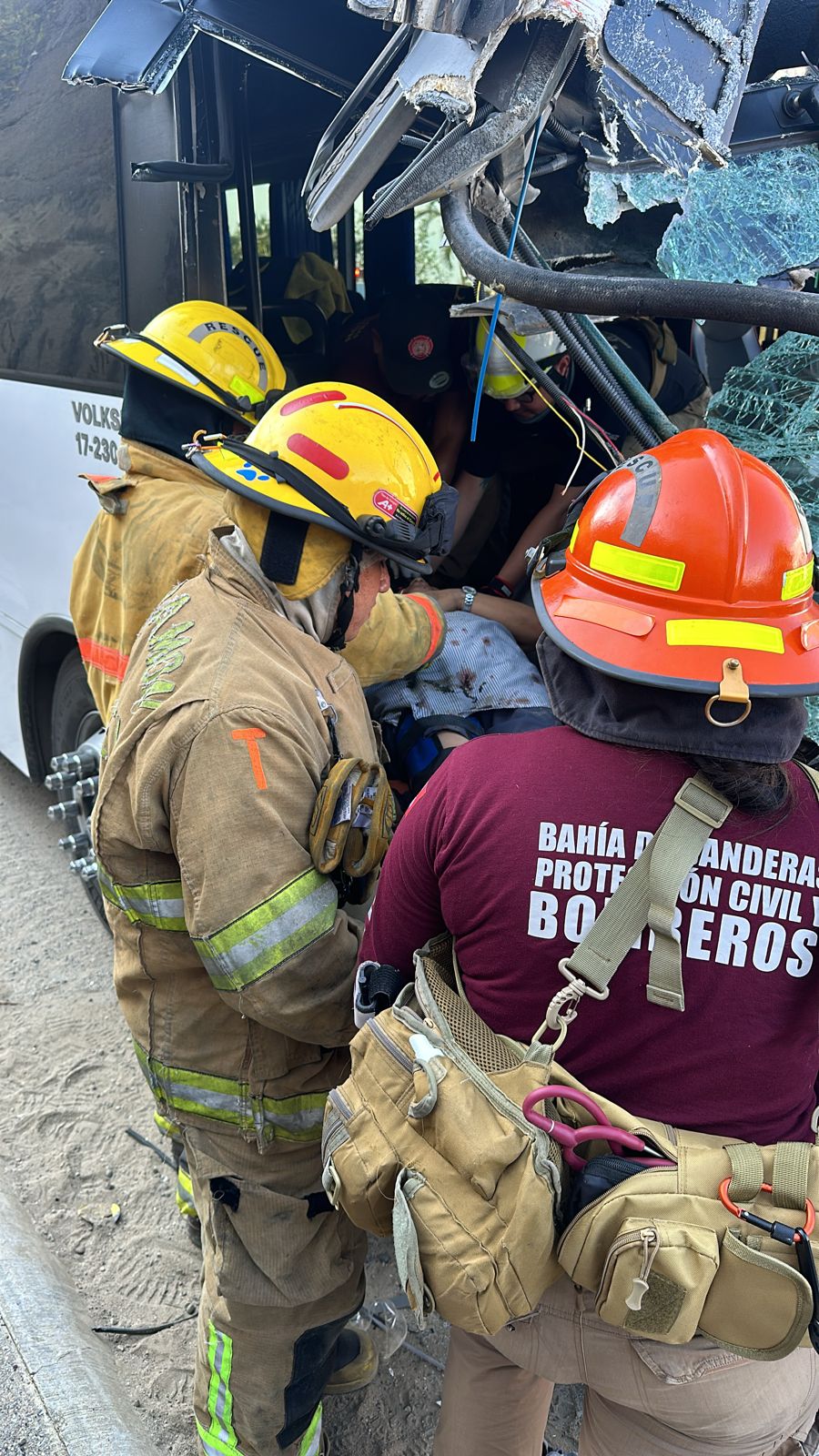 Paramédicos y bomberos atendiendo a trabajadores lesionados tras choque