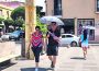 Personas se cubren del calor con un paraguas