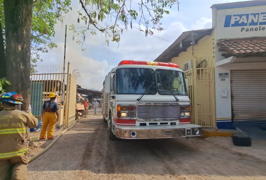 Camión de bomcaros en maderería incendiada