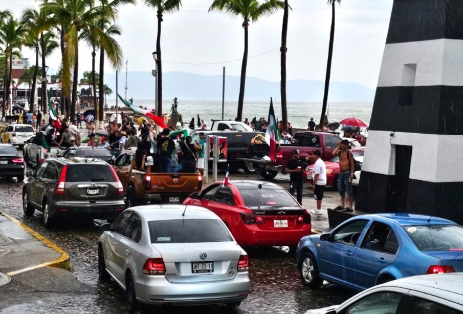 Malecón de Puerto Vallarta lleno de carros y grupos de personas