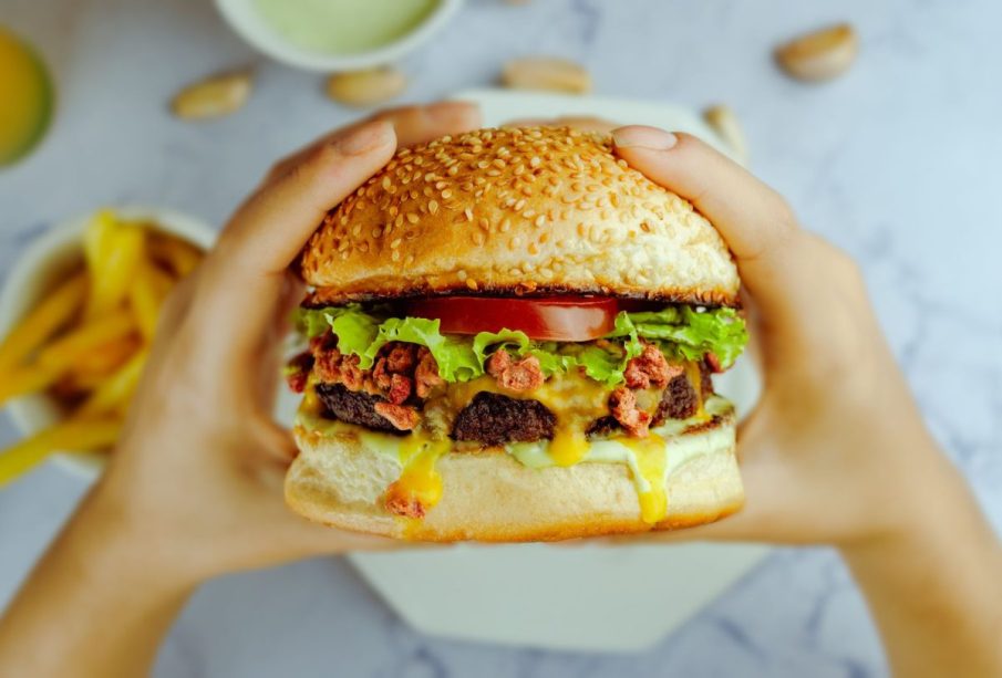 manos agarrando una Hamburguesa