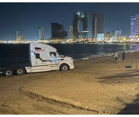 Conductor ingresa tráiler a playa de Mazatlán y queda atascado en la arena