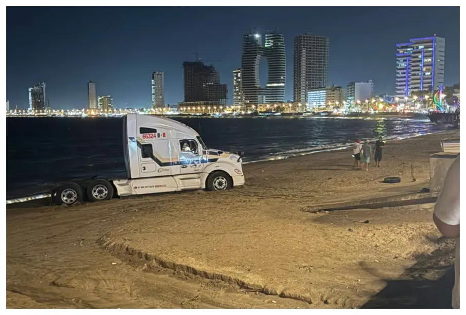 Conductor ingresa tráiler a playa de Mazatlán y queda atascado en la arena
