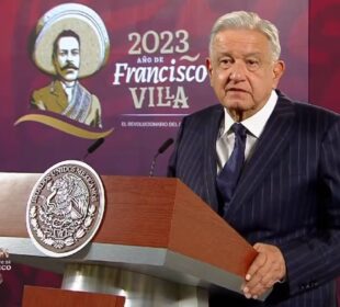 AMLO sosteniendose de podium