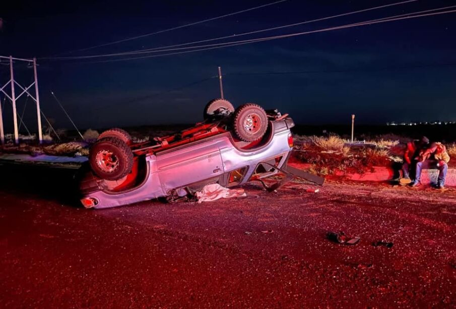 Cuerpo cubierto junto a camioneta volcada