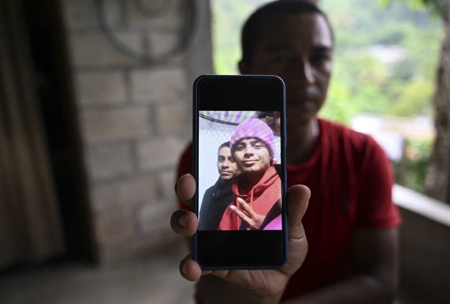 Hombre mostrando la foto de los jovenes migrantes fallecidos en Juárez