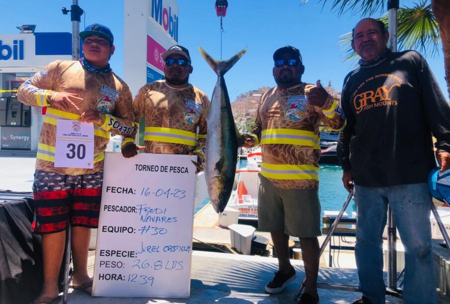 Hombres fotografiados con un pescado en el torneo de pesca de Los Cabos.