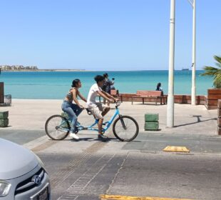 Jóvenes paseando en bicicleta en el malecón de La Paz.