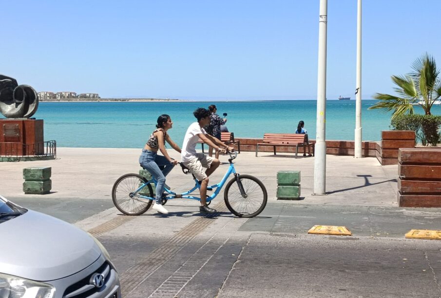 Jóvenes paseando en bicicleta en el malecón de La Paz.