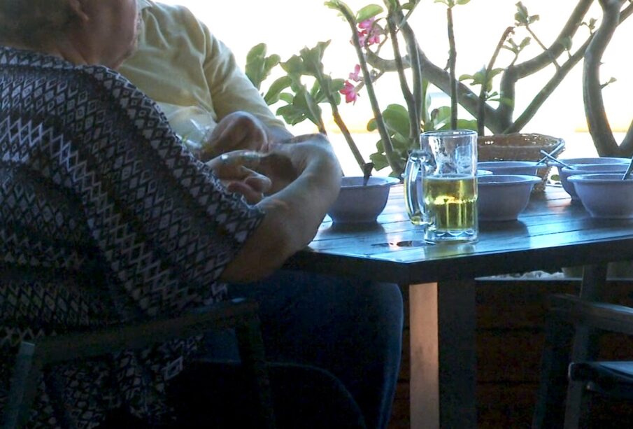 Mujer de la tercera edad bebiendo cerveza artesanal en un restaurante de La Paz