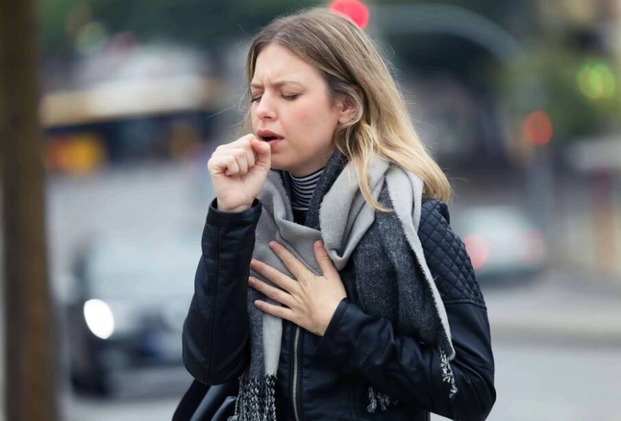 Mujer tosiendo y tocandose el pecho