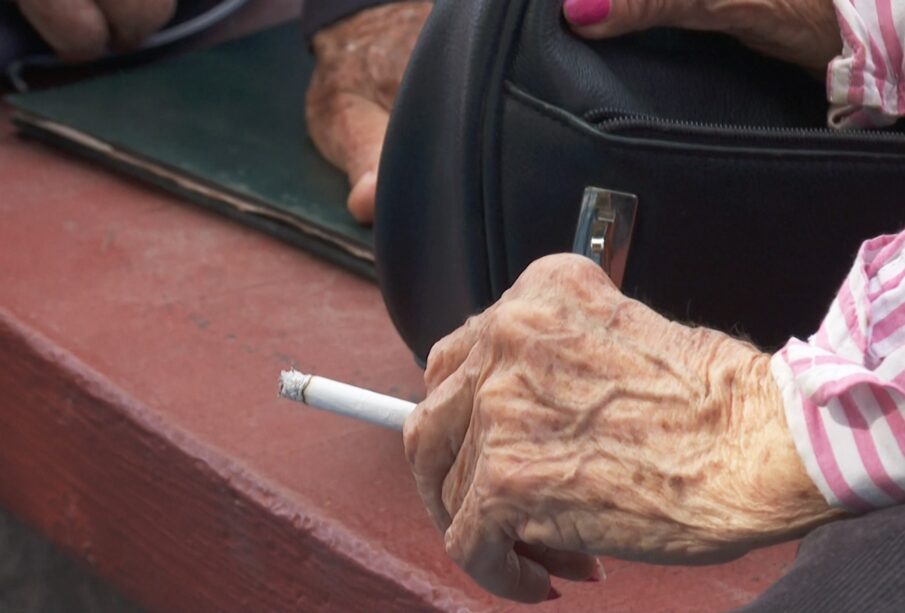 Persona de la tercera edad fumando un cigarro.