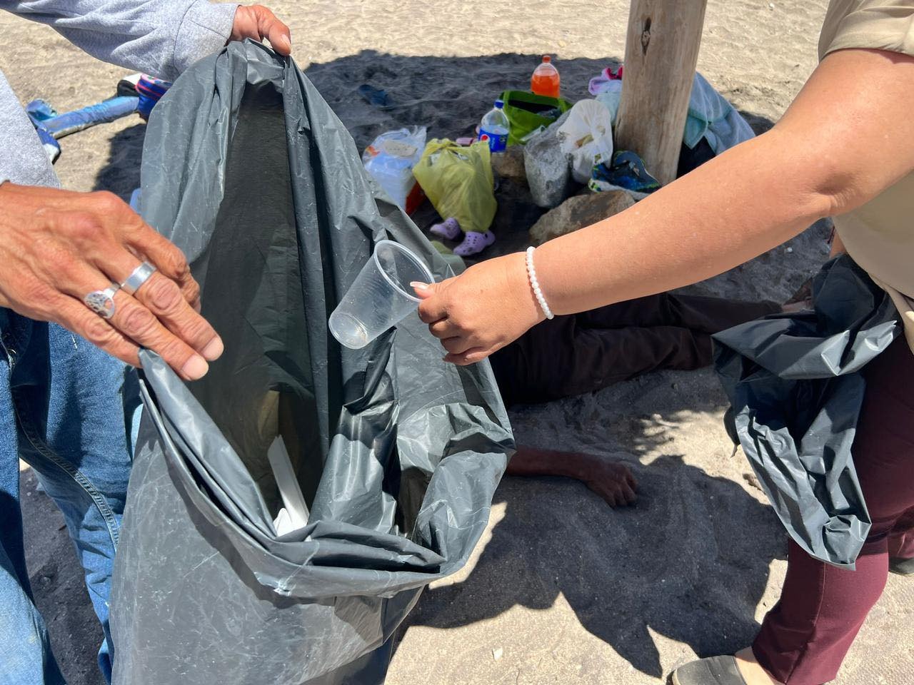 Personal de Servicios Públicos basura a una bolsa negra.