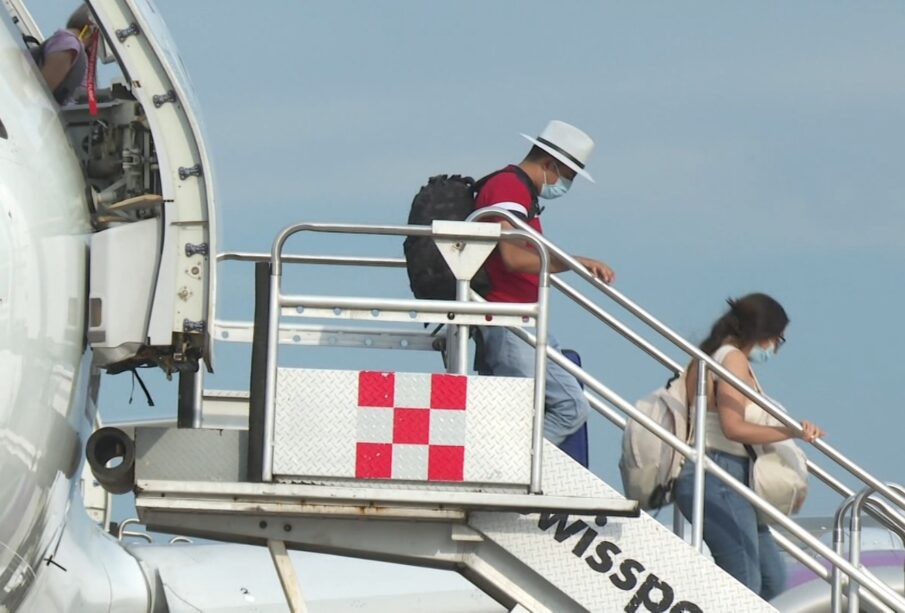 Turistas bajando de un avión.