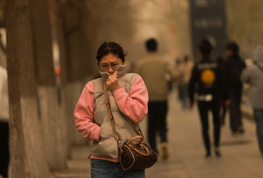 Una mujer camina por una calle durante una tormenta de arena en Shenyang, en la provincia nororiental china de Liaoning, el 11 de abril de 2023.