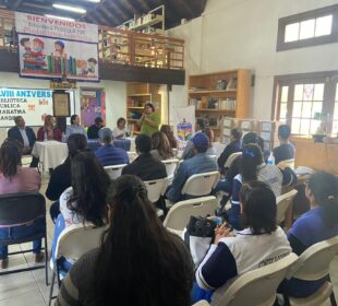 Personas escuchando una charla dentro de una biblioteca