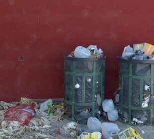 Botes de basura llenos y desechos regados en la banqueta