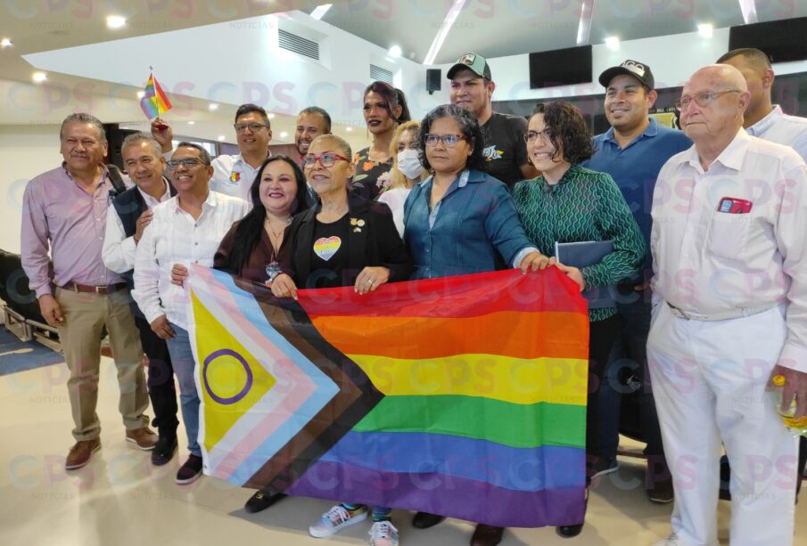 Personas posando con una bandera de la comunidad LGBT+