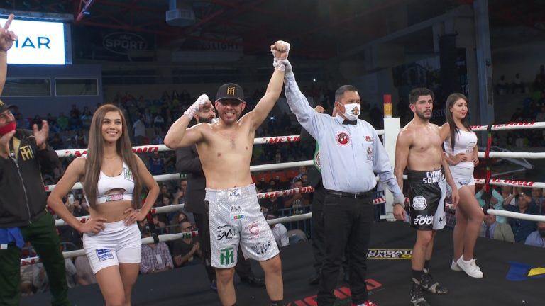 Un referee alzando el brazo de un boxeador