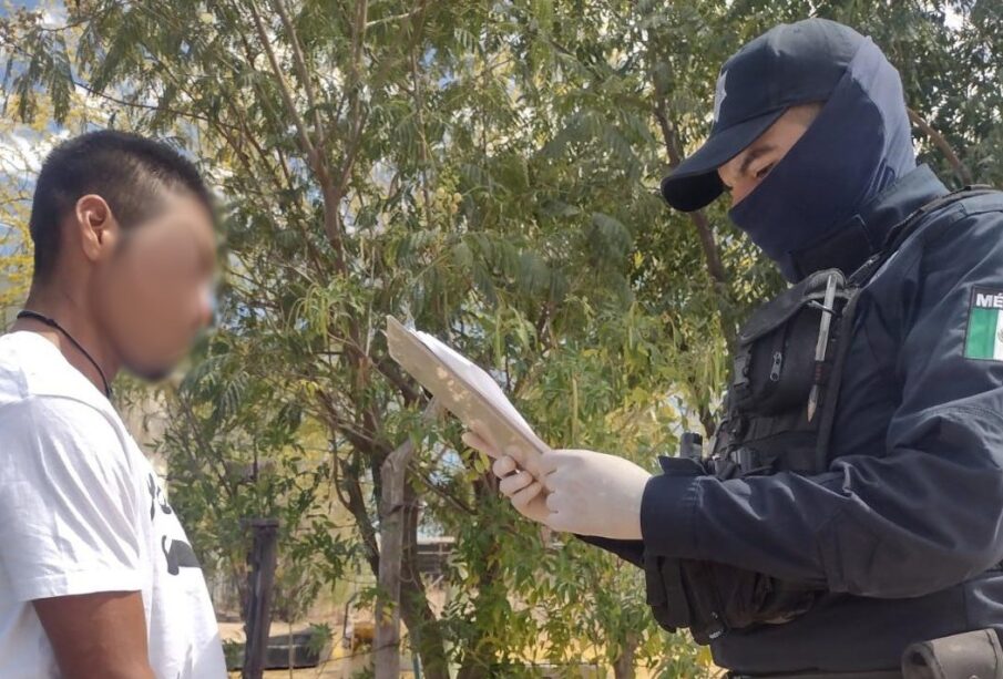 Un policía frente a un hombre con playera blanca