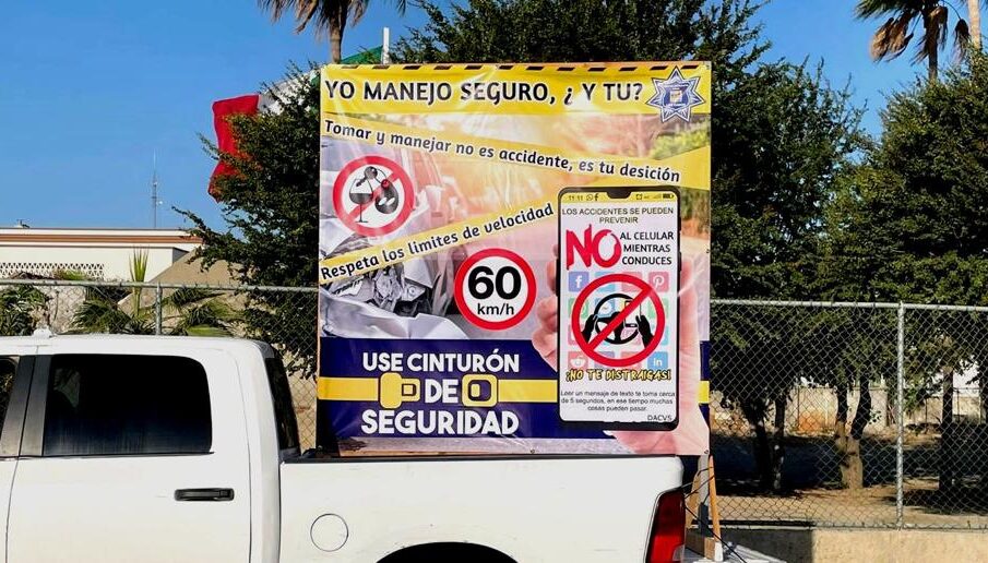 Una camioneta junto a una manta de indicaciones de seguridad