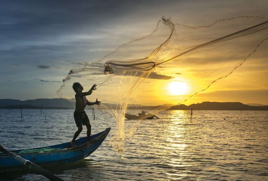 pescador lanzando red en el mar