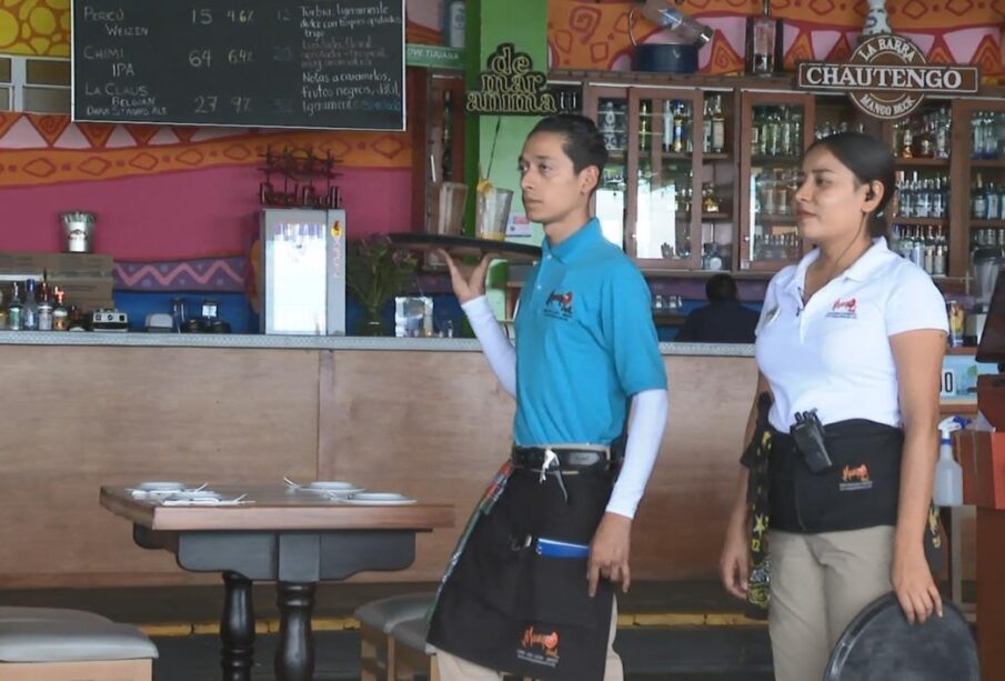 Mesero con una charola frente a una barra