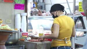 Una mujer manipulando alimentos con un cubrebocas puesto