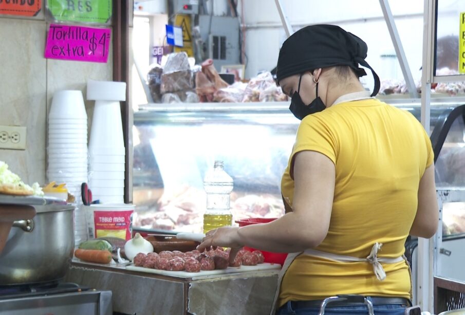 Una mujer manipulando alimentos con un cubrebocas puesto