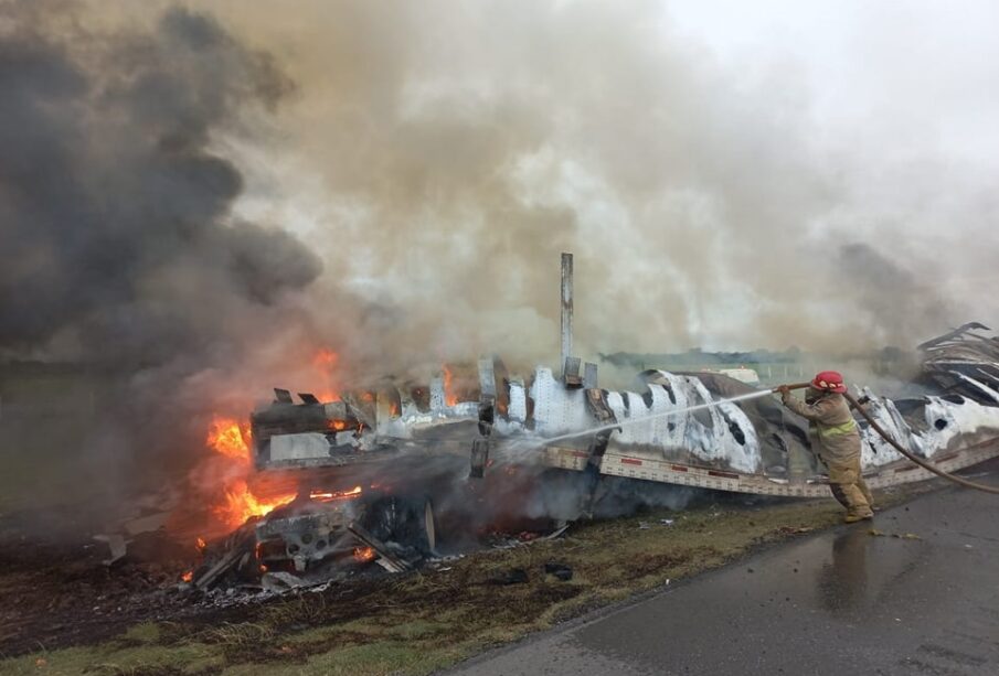 Bombero sofocando incendio en caja de trailer