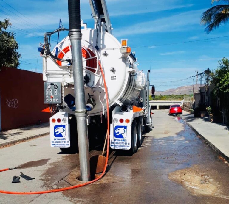 Camión desazolvando alcantarilla