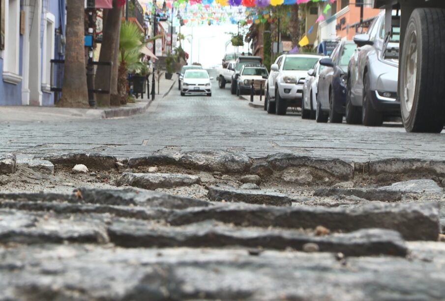 Imagen de bache a nivel de piso, con carros de fondo