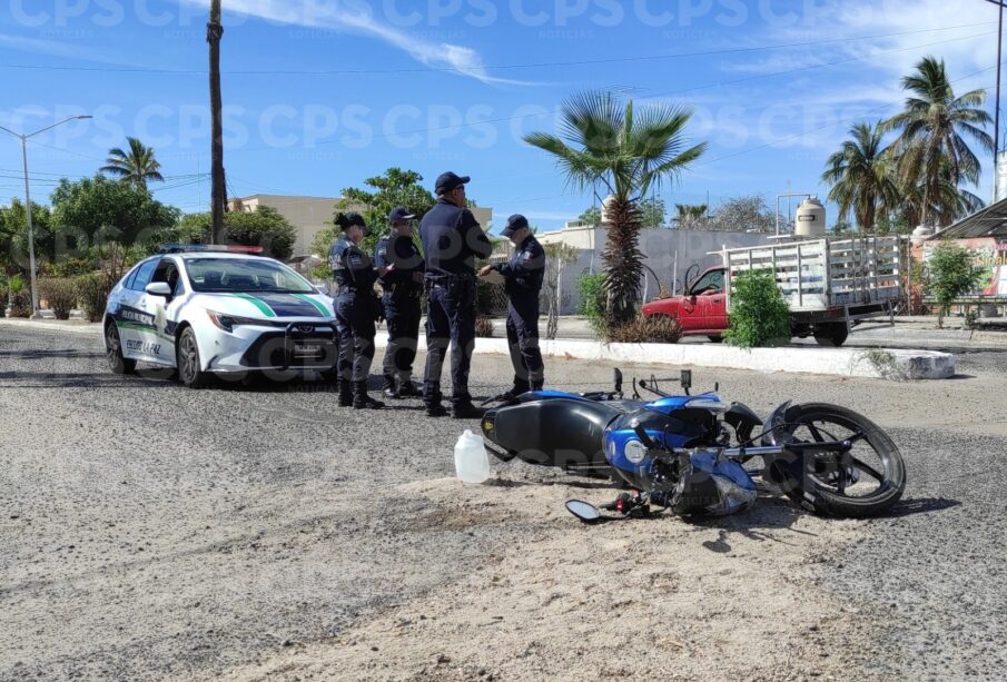 elementos de seguridad junto a una motocicleta tirada en via por accidente