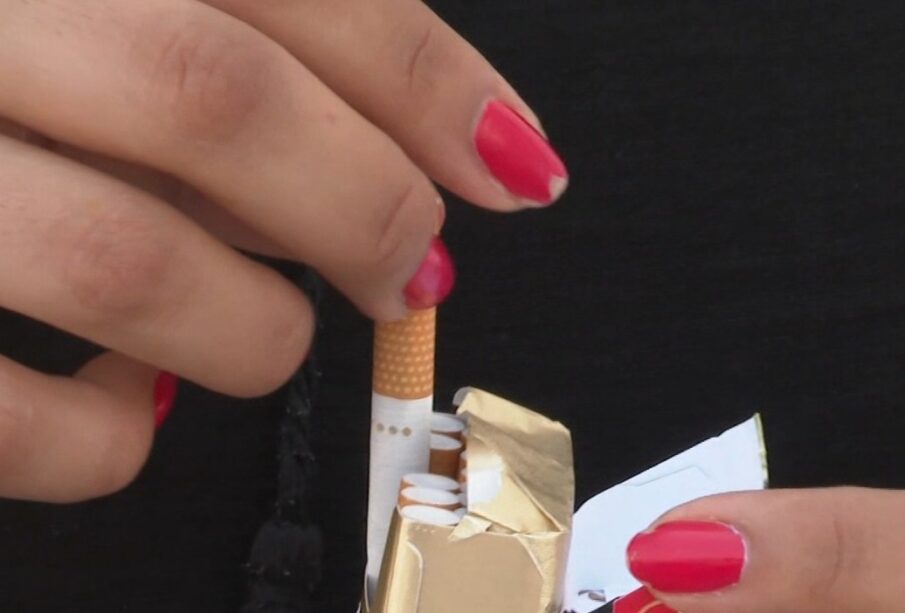 manos de mujer sacando cigarro de la cajetilla