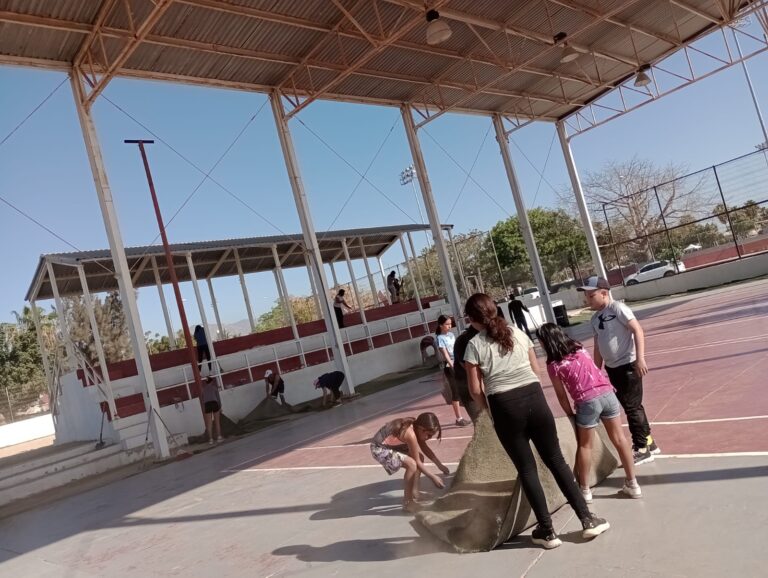 niños ayudando con limpieza de cancha