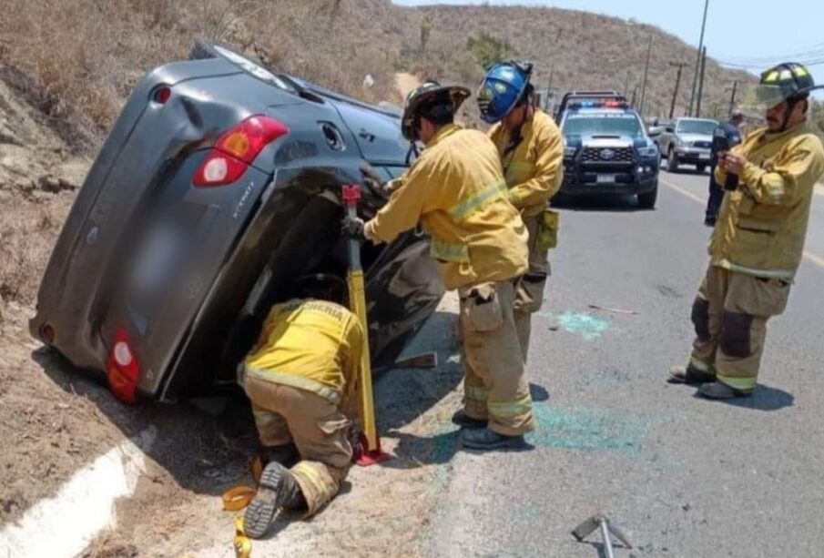 Cuerpo de Bomberos atendiendo volcadura de automóvil en la entrada a Todos Santos.