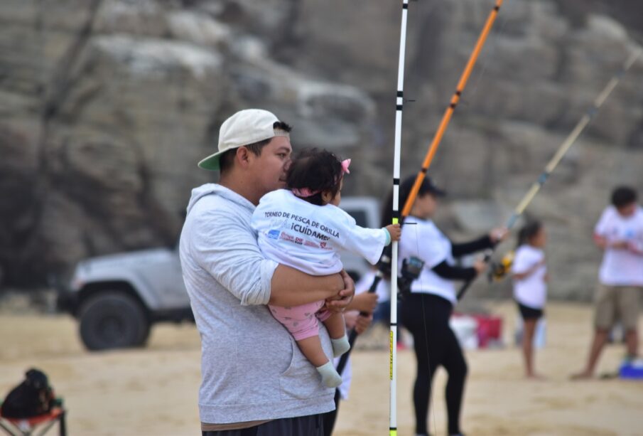 Padres e hijos pescando a la orilla de la playa en el Torneo Papá ¡Cuídame!