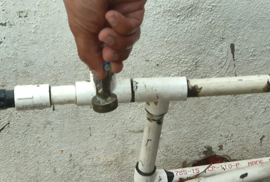 Persona abriendo llave de agua.